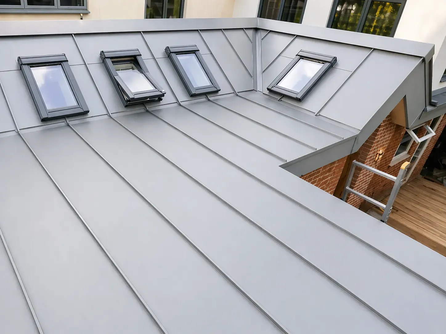 Zinc standing seam roof with multiple rooflights on a London townhouse extension