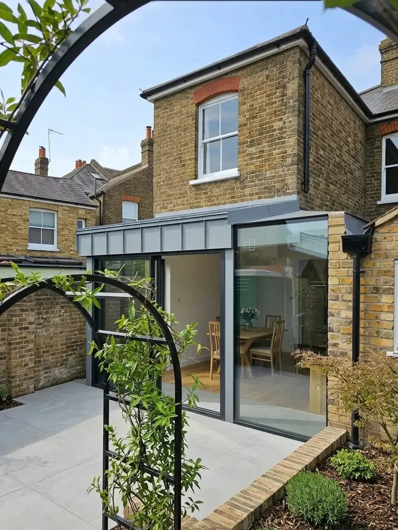 Aluminium canopy roof over a glazed rear extension on a brick house