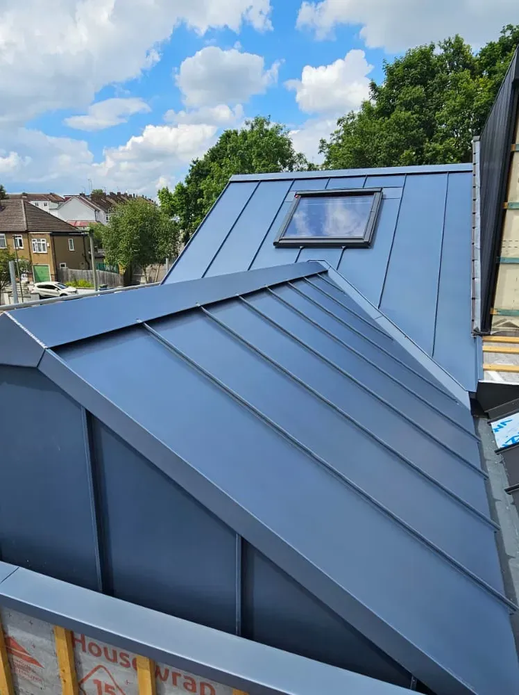 Anthracite zinc standing seam roof with a rooflight on a residential extension