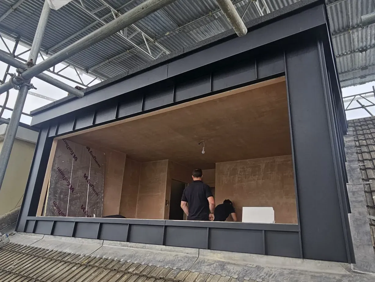 Dark aluminium-clad dormer with a large picture window under construction