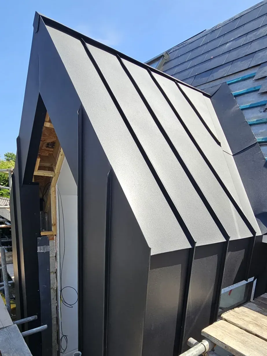 Black aluminium standing seam cladding on a sharply folded dormer