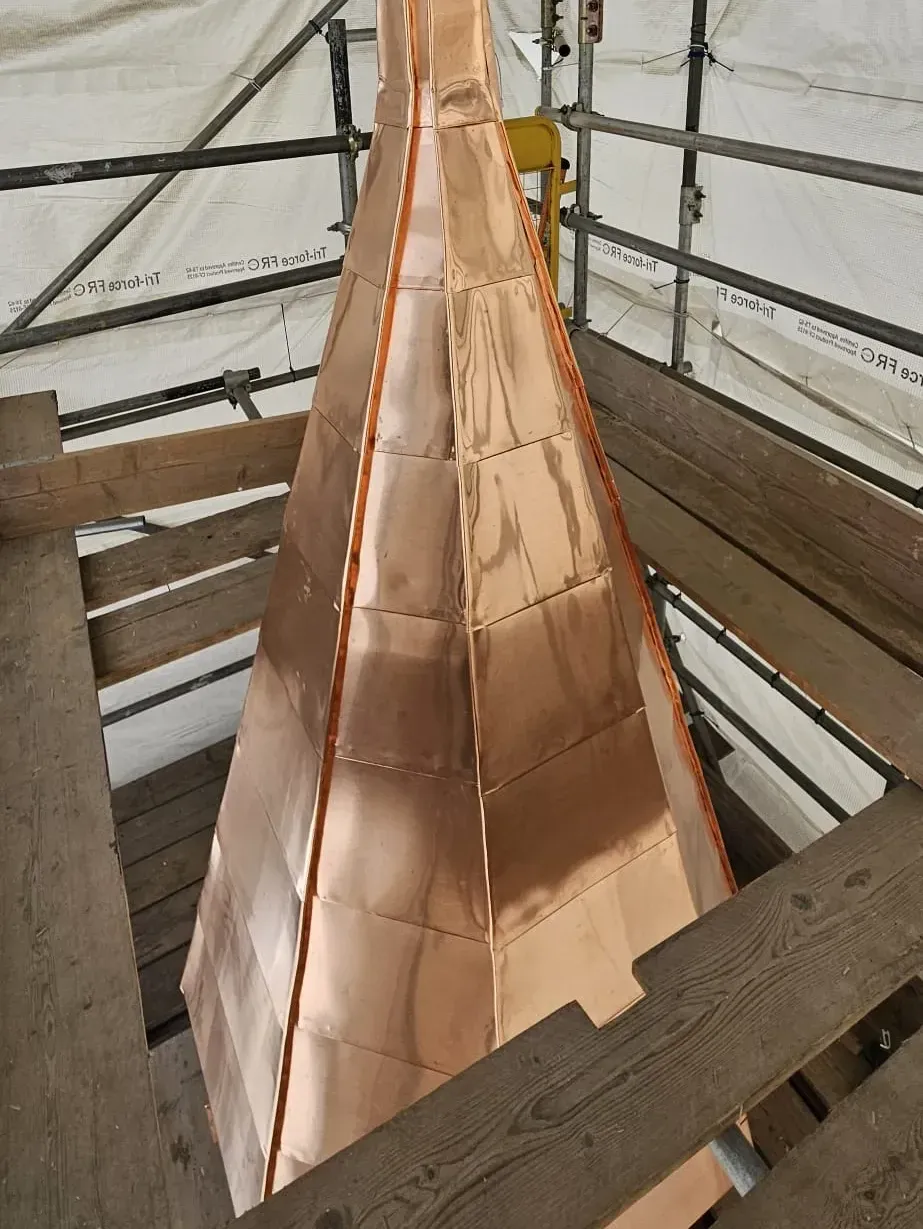 Copper-clad tapered spire viewed from above during installation