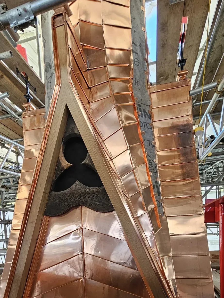 Copper standing seam detail on a complex tapered spire junction