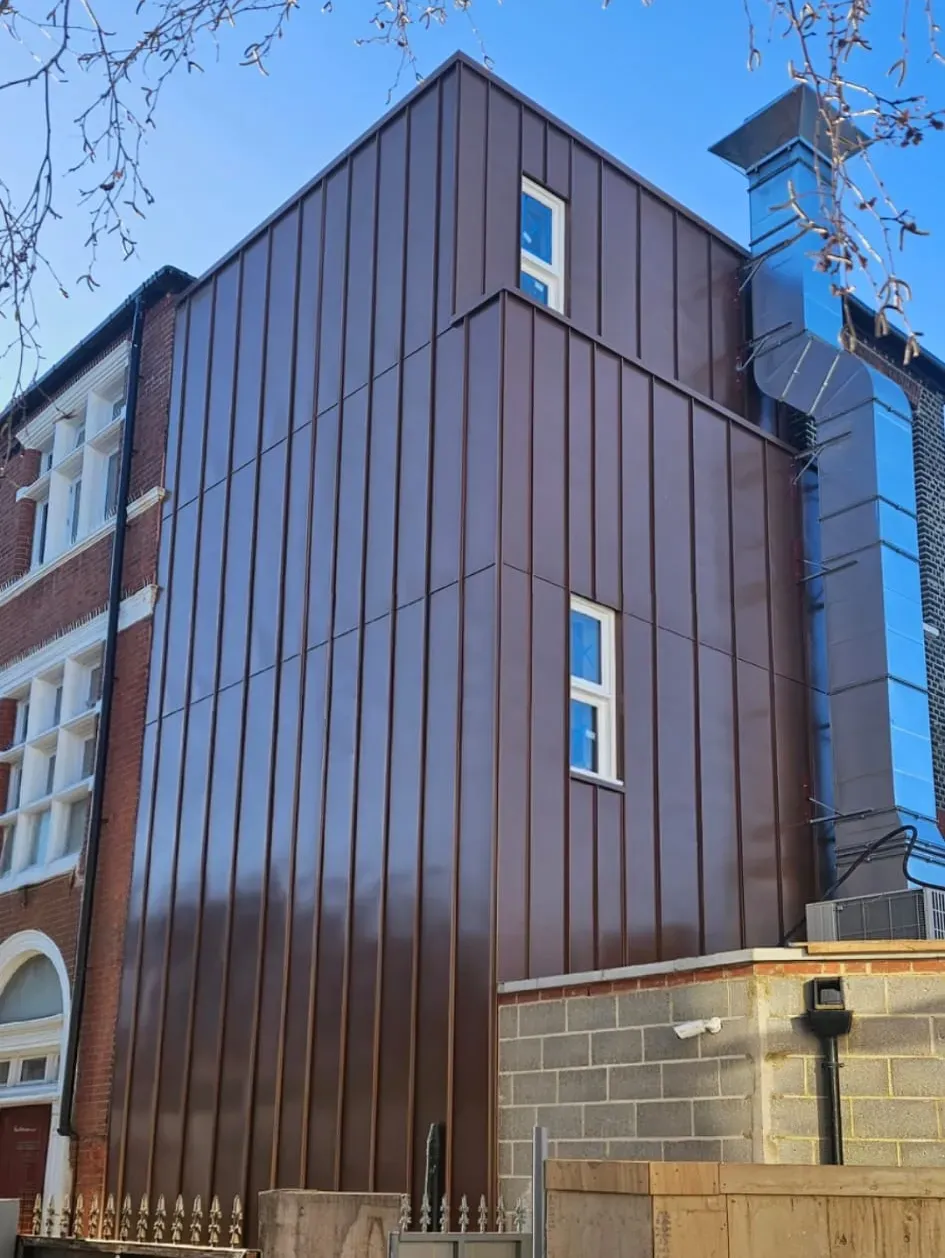 Brown steel standing seam cladding on a tall contemporary building facade
