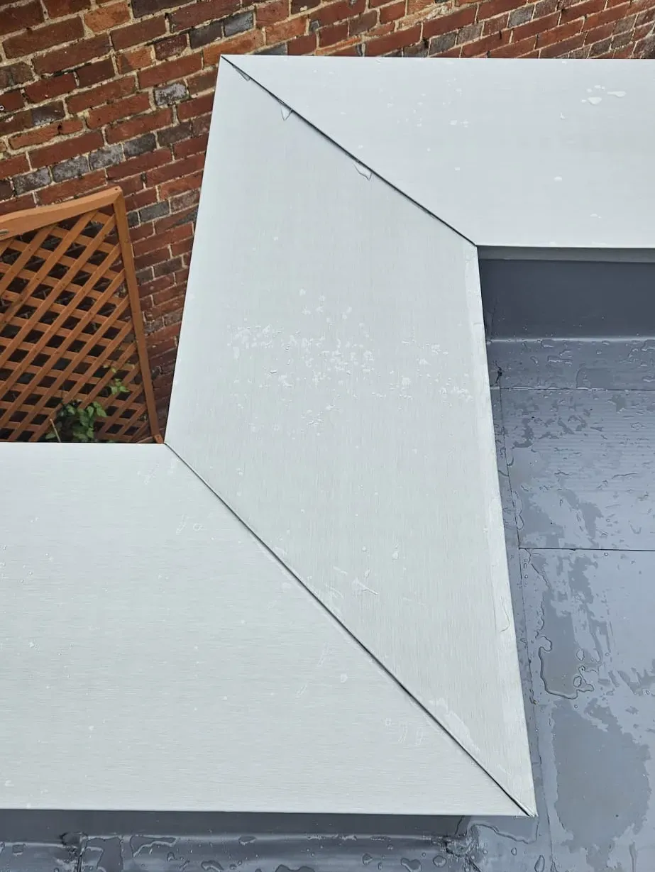 Close-up of a zinc coping corner and parapet detail