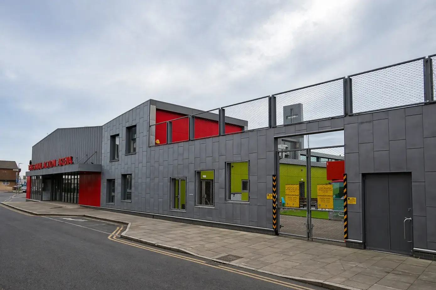 Large grey zinc-clad commercial building with coloured window accents