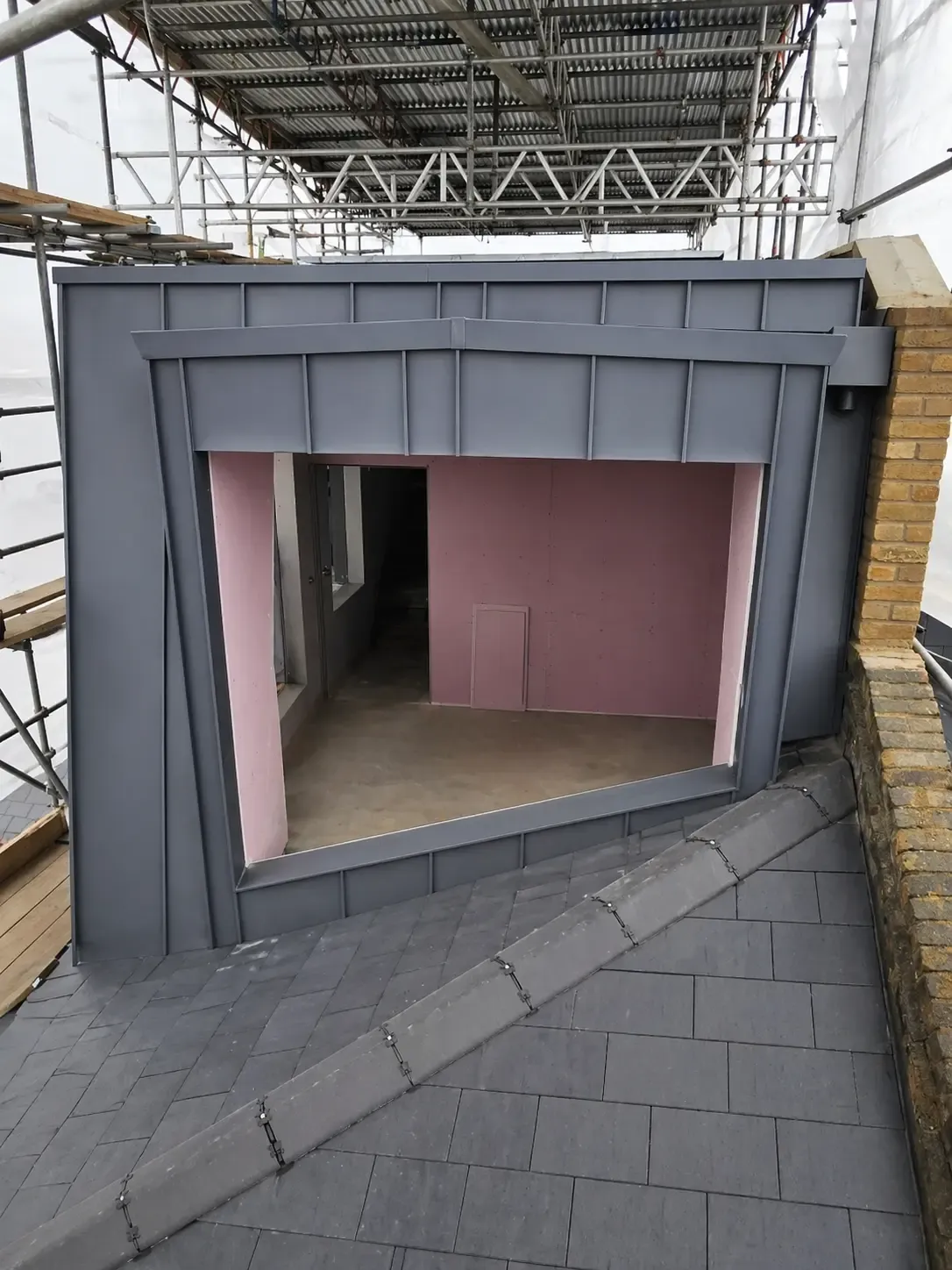 Zinc-clad dormer opening under construction with parapet and fascia details