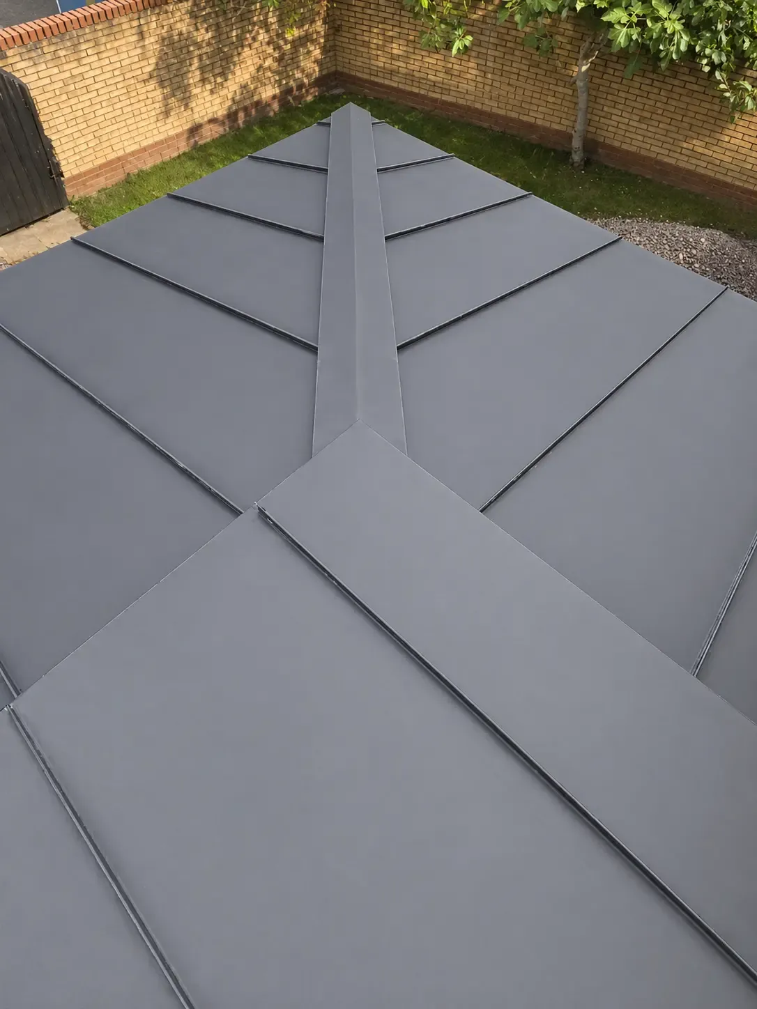 Dark zinc roof with intersecting diagonal standing seam layout