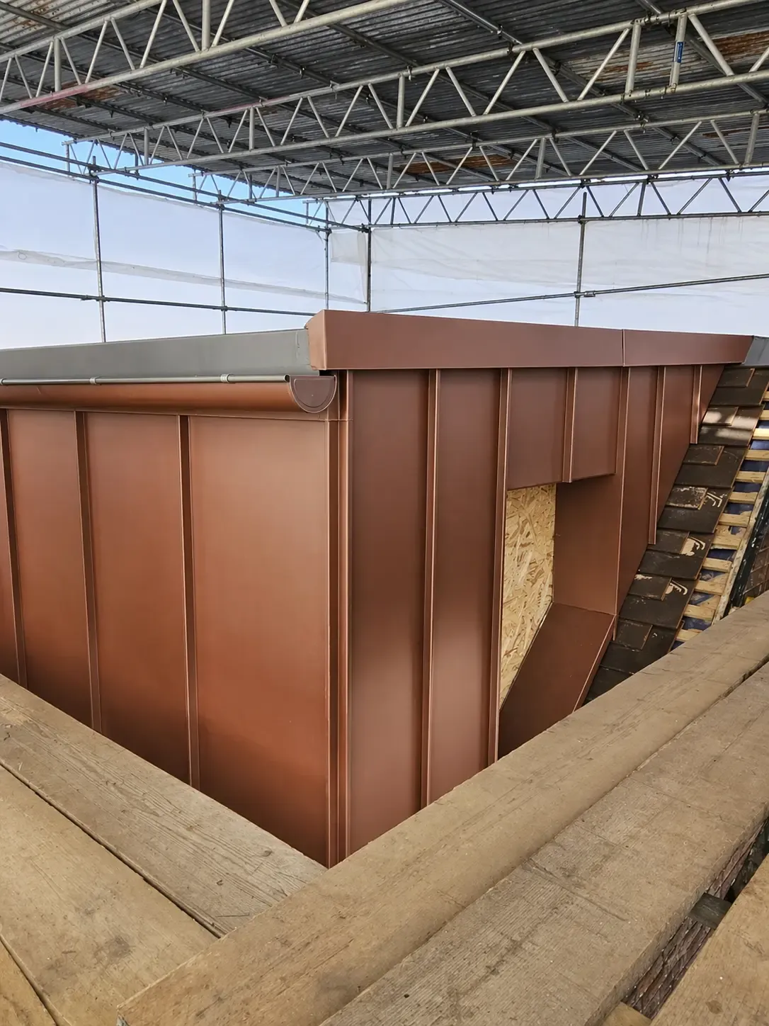 Brown zinc-clad dormer under construction with standing seam corner detail